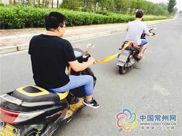 而两车之间竟用的是一根细布条系着,后车上也是骑着一名20多岁的男