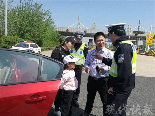 一家三口自驾游高速上遇爆胎 交警当起修车工