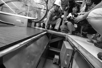 商场,沈阳特种设备检测研究院的检验人员向媒体介绍手扶电梯出口的