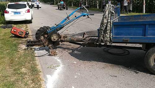 村附近道路发生一起交通事故,一辆手扶拖拉机与一辆白色轿车相撞