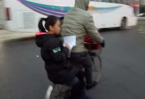 小女生坐在自行车后座上学习 这定力你服不