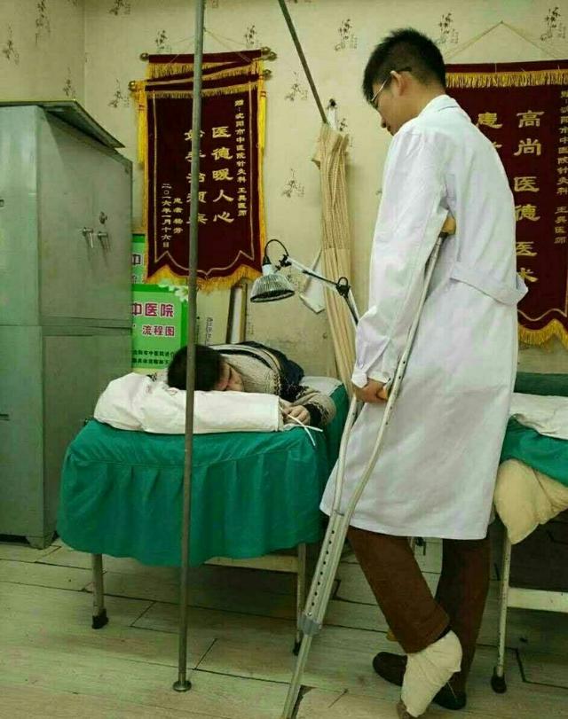 年轻医生左脚骨折 不顾病痛拄拐半跪给病人针