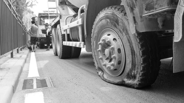 水泥罐车行驶中爆胎 崩飞并行摩托上两个人(图