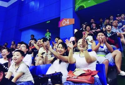 在龙江体育馆举行的女子摔跤比赛中 运动员比赛结束后观众鼓掌喝彩.