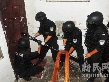 特警队员用专用的液压破门器打开犯罪嫌疑人铁门