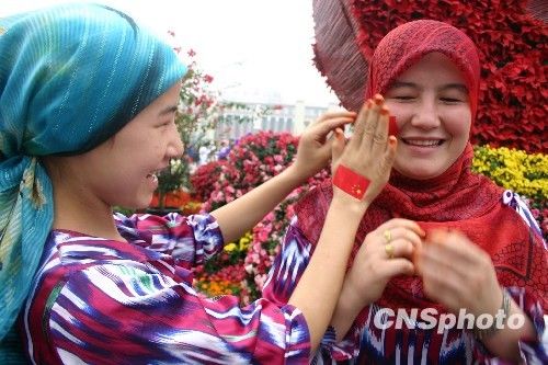 图文:新疆维吾尔族姐妹脸贴国旗装
