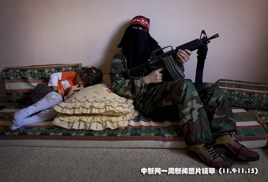 12日(周四),一名<em>巴勒斯坦妇女</em>在家中手拿枪支