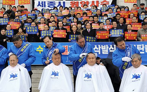1月11日，韩国首都首尔市一批在野党议员在韩国议会大门前集体剃头，表达自己对政府修改“韩国新行政首都世宗市建设规划”的不满