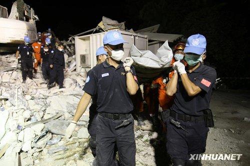 1月16日,在海地太子港,中国维和xx防暴队队员在联合国驻海地稳定特派团倒塌大楼现场抬出一具中方失踪人员遗体. 当日,中国国际救援队在海地太子港地震现场挖掘出一具中方失踪人员遗体,并举行了简短的现场默哀仪式.新华社记者 袁满 摄