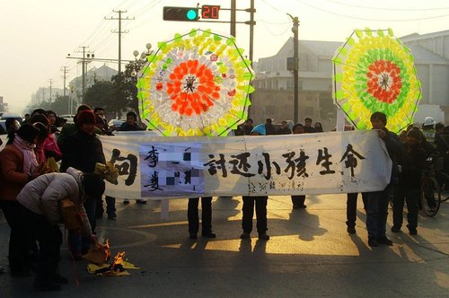 1月7日，江苏邳州市河湾村，200多名男子手持棍棒、砍刀，欲强行征用该村耕地，与前来护地的百余村民发生冲突，村民一死一伤。当地警方称，涉嫌行凶的30人被控制。当地政府曾动用防暴警察抢尸。图为尸体被抢，村民们走上大街讨说法。