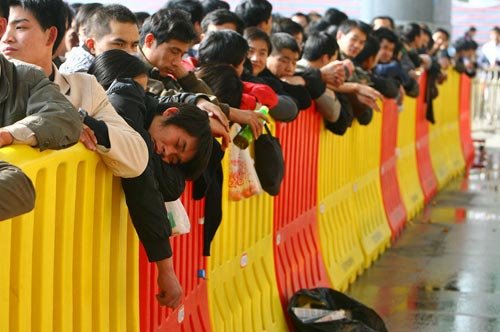 月20日下午，宁波国际会展中心铁路临时售票点，长长的队伍中，从广西来此打工，已经3年没有回过家的小伙子梁献贵趴在隔离栏上酣然入眠。