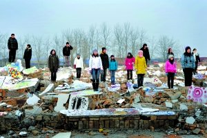 2009年12月26日,北京市创意正阳艺术区内,一群艺术家站在工作室的废墟上,向拆迁方表示无声的抗议。艺术家们持续的维权取得阶段性的胜利,赔偿费由原先的分文不给上升到500万元人民币。