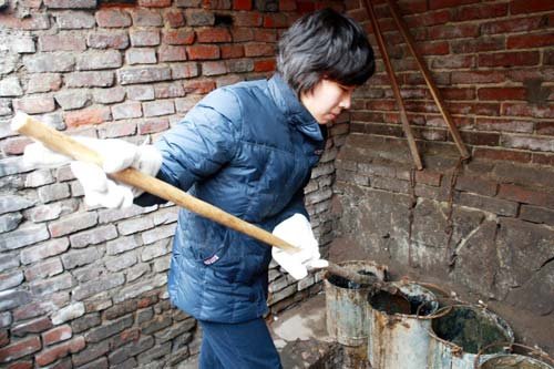 女大学生张婷一丝不苟地做着掏粪工作.