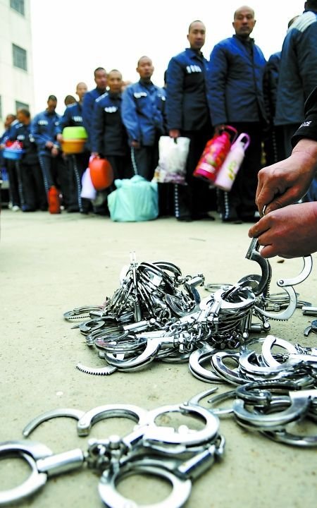 为了保证搬迁安全，上车前每两个在押人员戴一副手铐