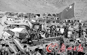 救援队员在地震废墟上默哀。 特派记者杜江摄