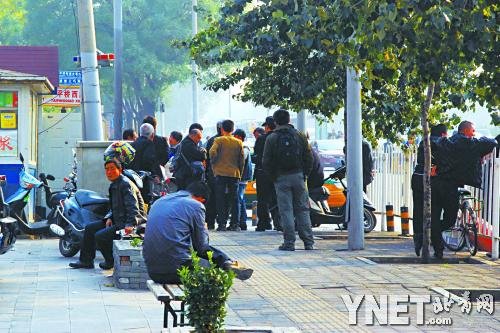 身份不明的“便衣队”乘坐无牌面包车，时常突击“巡街”，专查商贩黑摩的。图为前天下午，参与联合执法的“便衣”围住了一名无照摩托车司机。