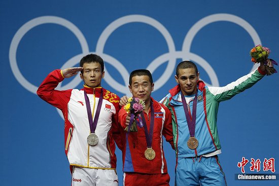 当地时间7月29日晚，在伦敦奥运会男子举重56公斤比赛中，朝鲜选手欧云哲夺得金牌，中国选手吴景彪（左）屈居亚军，阿塞拜疆选手赫里斯托夫获得铜牌。记者 盛佳鹏 摄