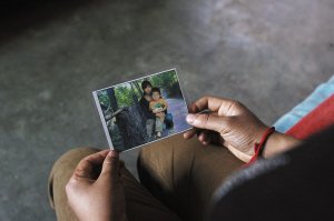 杨其聪的儿媳拿着自己和儿子的照片 文若愚 摄
