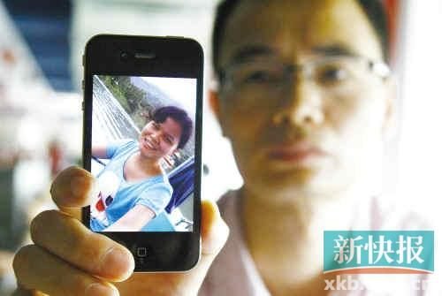 李嘉丽的哥哥拿着她的照片。新快报记者 毕志毅/摄