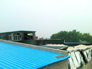 被烧毁的天井和楼顶房屋，都是用彩钢板搭建的。本报记者 段修建 摄