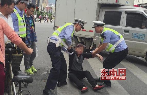 福建一妇女闯红灯被拦 为逃处罚跪地上躺马路(图)