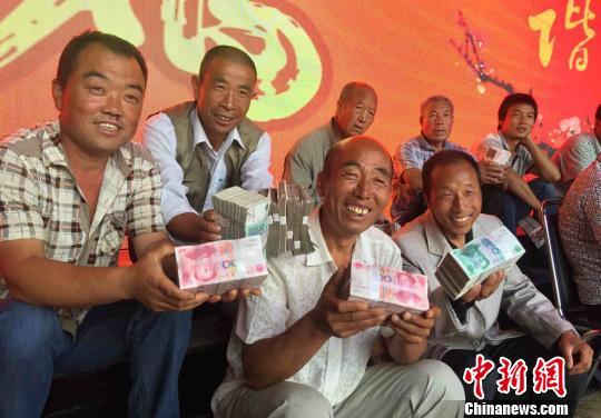 百元大钞堆“钱山”:村支书千万现金分红村民(图)4