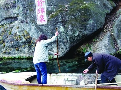 游客湖中投币求平安 有人划船用磁铁“吸金”