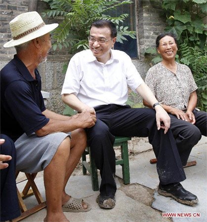 2010年7月8日,李克强在济宁市嘉祥县大孙村慰问困难群众时,与贫困户孙树节一家亲切交谈。新华社