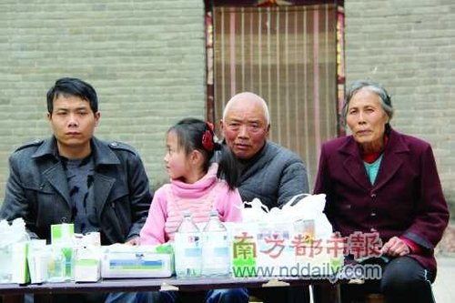 张海超一家与药品合影。张海超和父母都有重病,他说大人们都活不了太久,想找人收养女儿。