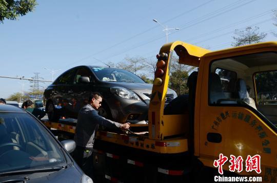 14日上午8时许，广州发生道路塌陷，惊现5米多深的“天坑”，车身大半截悬空的小车被安全吊离。朱嘉玮摄