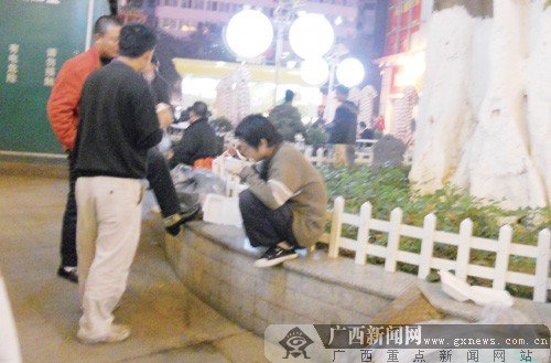 万达广场美食街一名“吃剩饭族”在吃剩饭