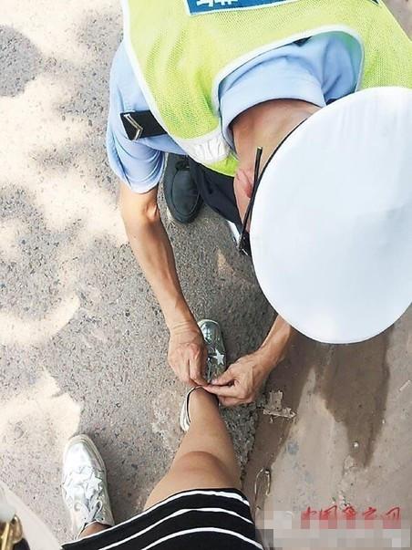 女子车祸手指骨折 警察俯身帮系鞋带