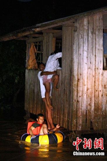 热带风暴“天鹰”连日来在菲律宾南部多个省份引发严重洪灾，图为12月17日凌晨洪灾爆发之初在重灾区卡加延德奥罗市，一名士兵利用小橡皮艇从窗户中解救被困的居民。中新社发 欧文·马斯卡里纳斯 摄