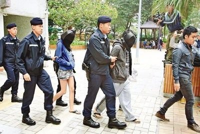 警员拘捕2名涉踢死流浪猫的青年男女.图片来源:香港《文汇报》