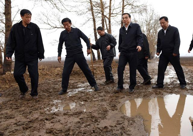 李克强雨中翻地看墒情