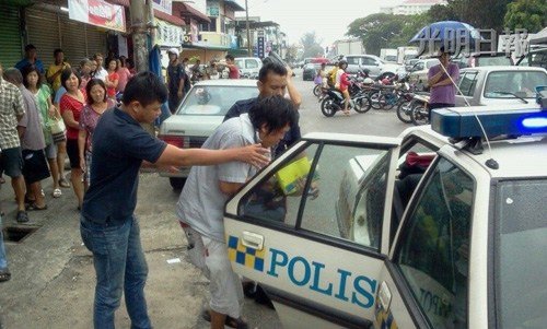 警方将嫌犯押上警车,以带返警局调查.