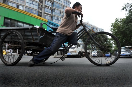 独腿男子蹬三轮捡破烂为儿还债 拒上街乞讨