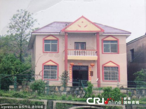 翻拍图：2013年4月27日，曹振宇的家是一栋非常漂亮的两层居民楼，粉色的外墙砖和红色的琉璃瓦在青山的映衬下显得格外引人注目。图片来源：佚名/东方IC 