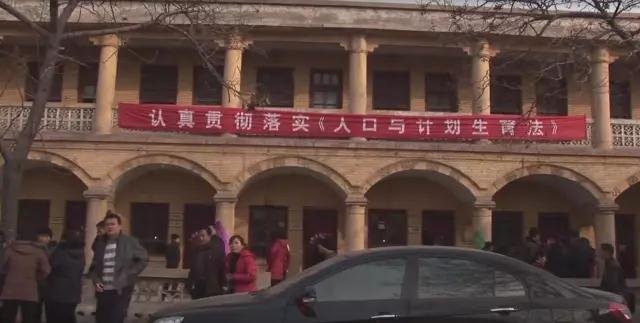 纪录片《妈妈的村庄》剧照,“认真贯彻落实《人口与计划生育法》”横幅。 纪录片《妈妈的村庄》剧照,“认真贯彻落实《人口与计划生育法》”横幅。