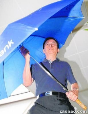 新加坡华人医生王腾吉个子不高，撑着大伞离开法庭。（新加坡《联合早报》援引海峡时报）