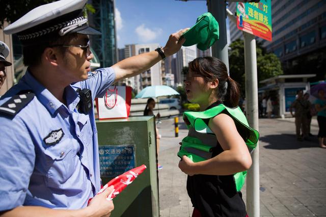 組圖：深圳市民闖紅燈被罰戴綠帽執(zhí)勤