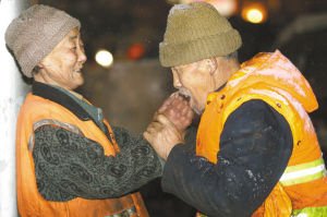 [转载]环卫老夫妻扫雪感动网友 老大爷为老伴暖手(图)