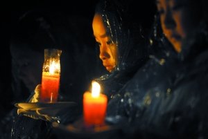 小学生代表在雨中手捧红烛。昨晚，南京大屠杀遇难同胞纪念馆集会广场举行“和平烛光祭”活动，国际友好人士及北京、沈阳、福建等地的代表与南京市小学生代表们一起，点亮代表悼念30万遇难同胞的3000支红烛。新华社发