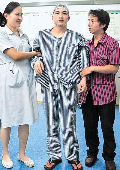 6月12日,“夺刀少年”柳艳兵在护士和家人的搀扶下下床行走。魏本貌 郝士芳摄
