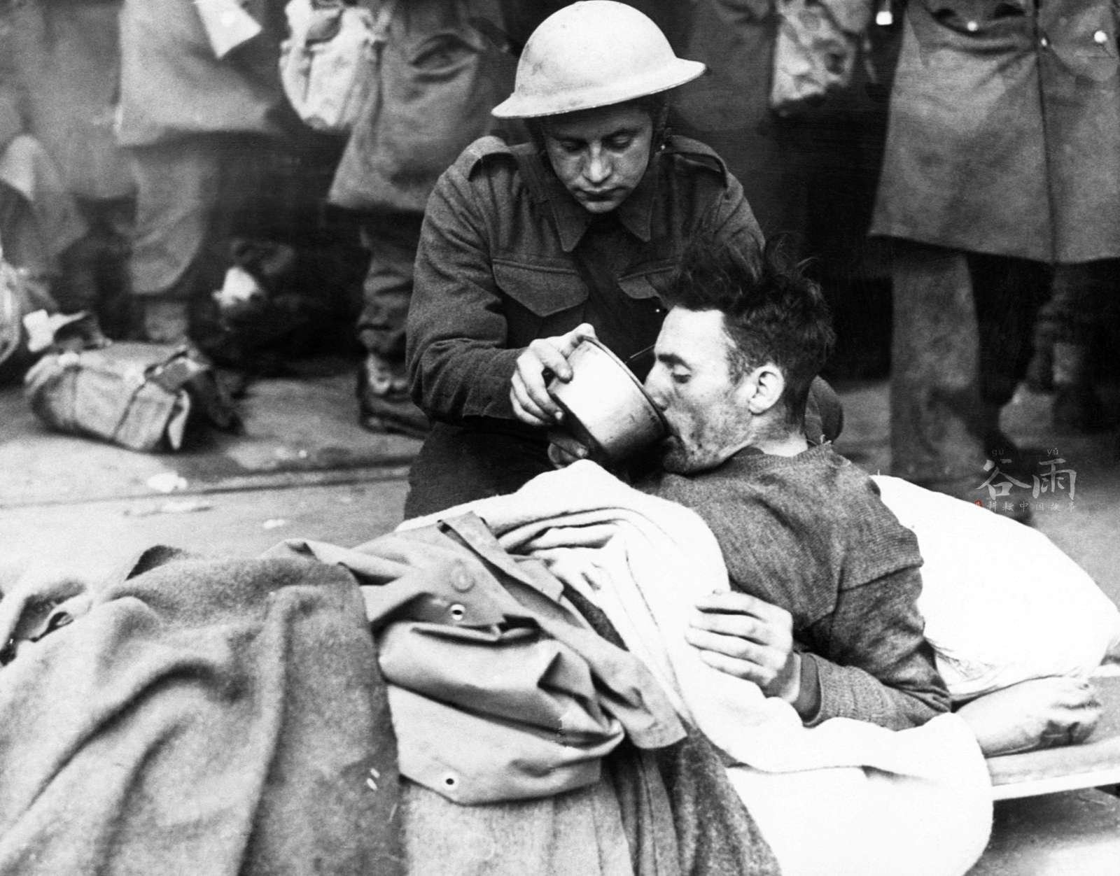 一名英国士兵正在照顾伤员。 一名英国士兵正在照顾伤员。