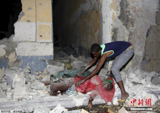 当地时间2月26日，据索马里警方说，首都摩加迪沙一酒店和一运动场当晚发生自杀式炸弹袭击，已造成至少12人死亡、16人受伤。索马里极端组织“青年党”宣称制造了这两起袭击事件。图为当地民众和一位遇难者。