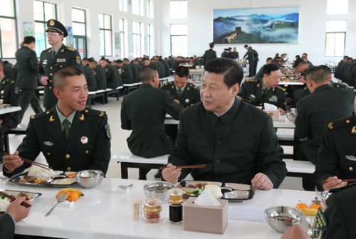 这张资料图片拍摄于2012年12月份，习近平在广州军区视察时与士兵一起午餐。