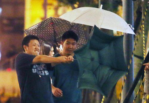 中度台风“鲇鱼”直扑台湾，台北市9月26日入夜后雨势渐强，伴随突来的强阵风，让路上行人雨伞不时开花，颇为狼狈。台湾《联合报》记者胡经周／摄影