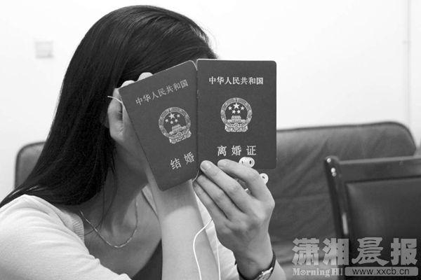 受害人拿着陈尔康（化名）用于欺骗她的假结婚证、离婚证。图/潇湘晨报记者覃剑