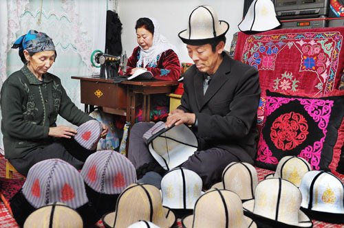 3月30日,柯尔克孜族毡帽制作高手居玛(右)在制作毡帽.